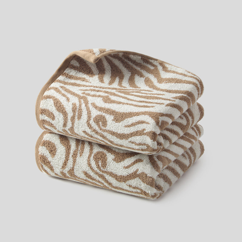 Brown zebra hand towels in a 2-pack, folded to show the soft 100% cotton zebra stripe pattern