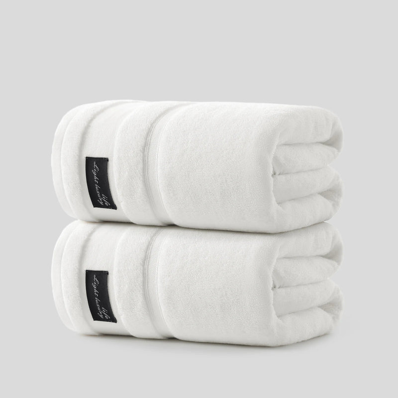 Two folded white REDKISS cotton bath towels stacked as a matching set, with a clean spare ready for daily bathroom rotation. #color_white